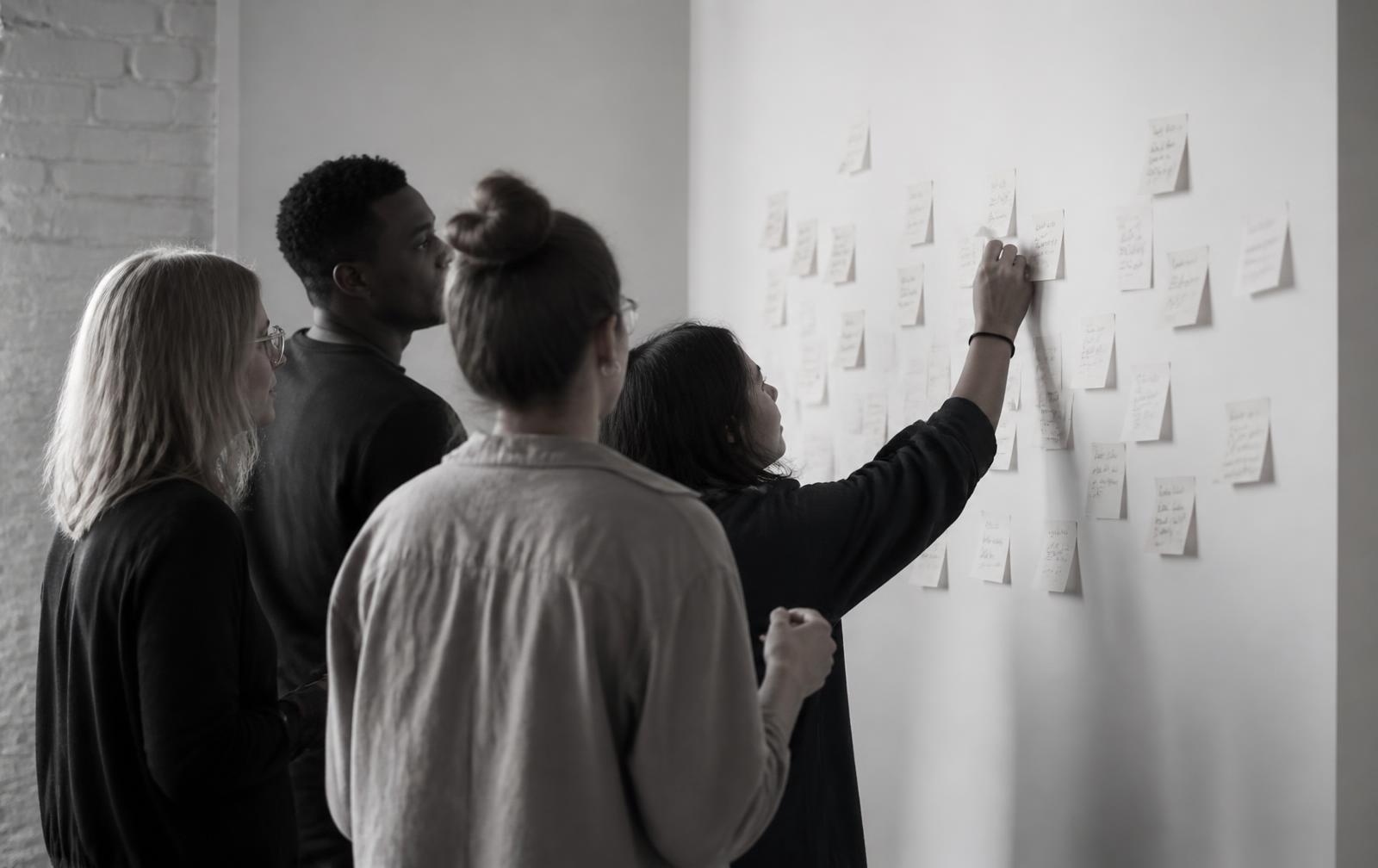 Workshopgruppe an einer Wand mit Notizen